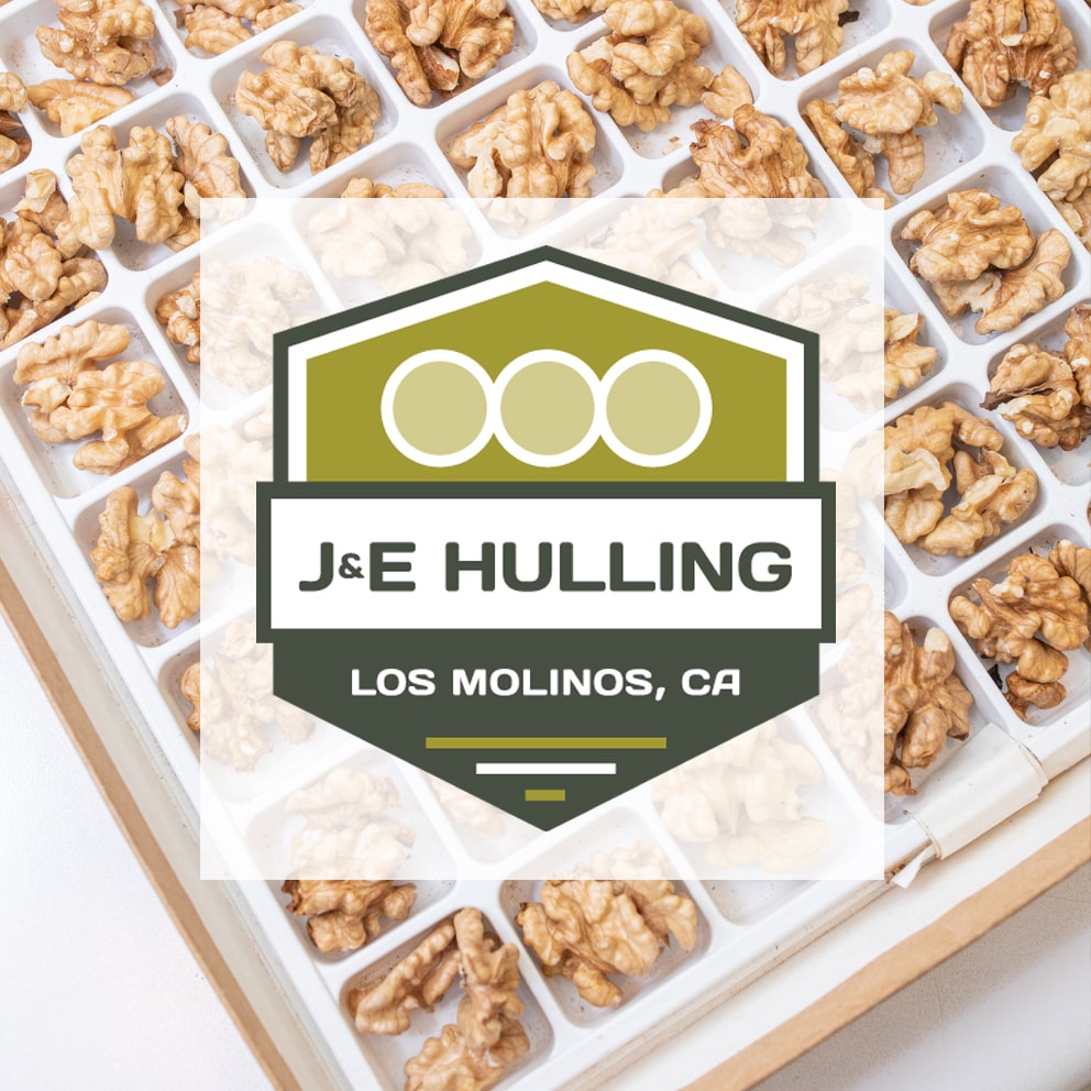 J&E Hulling logo with walnuts in the background